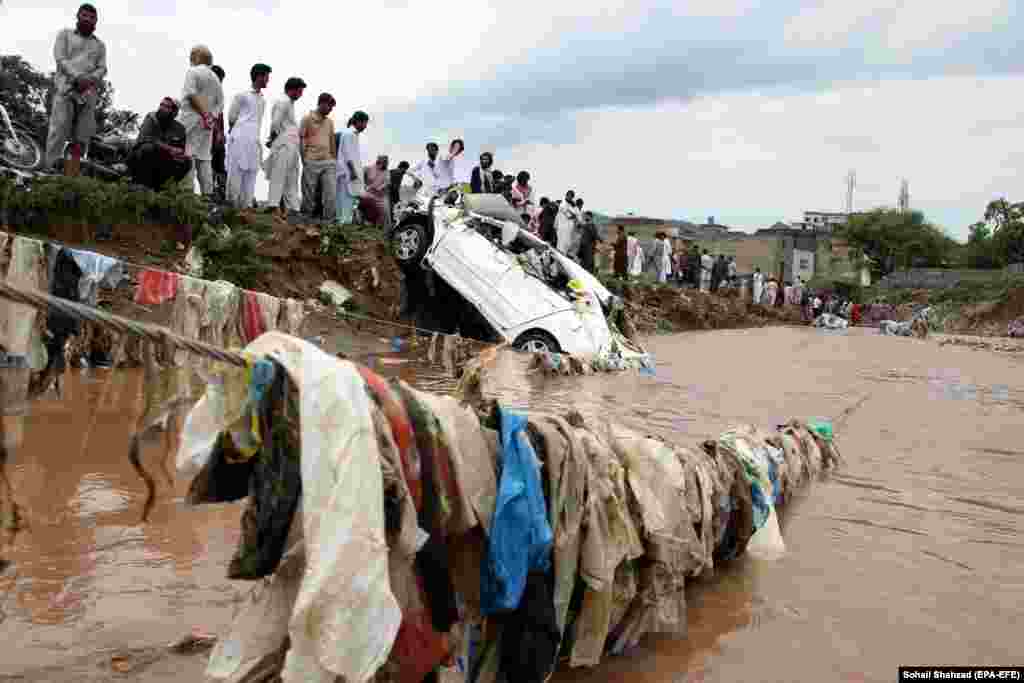 A crowd of people watches rescue operations being carried out after flooding caused by a cloudburst in the Pakistani capital, Islamabad, on July 28.&nbsp;
