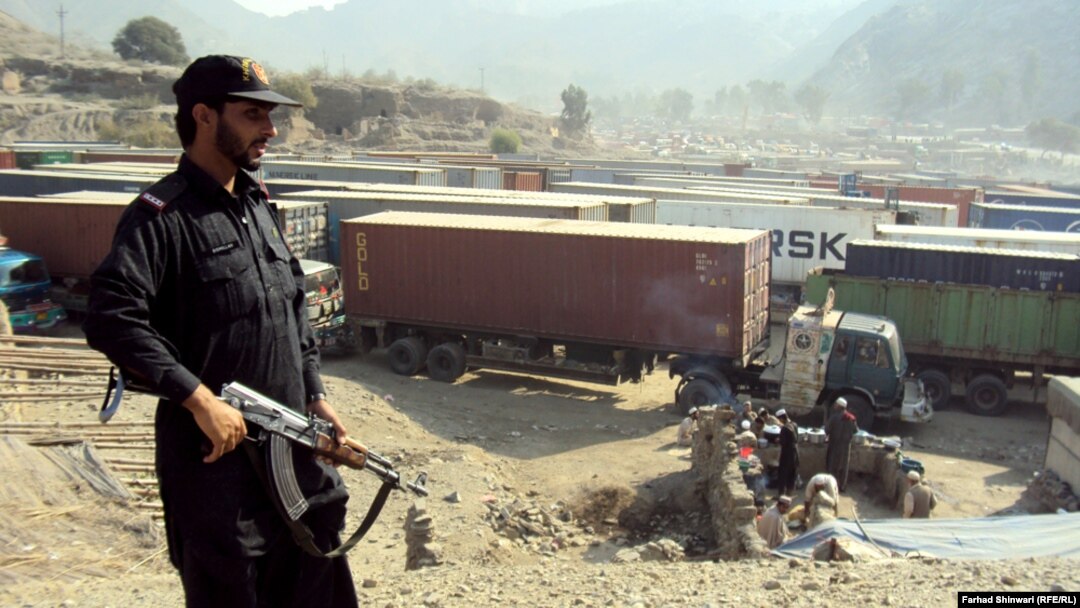 A Pakistani security officer stands guard over long lines of NATO trucks and oil tankers at a border crossing amid a blockade against NATO vehicles transporting supplies to Afghanistan via Pakistan. The blockade has been in place since November 26, when 2