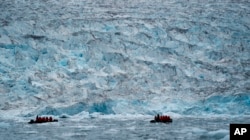 Dy grupe turistësh duke shikuar akullnajën në Scoresby Sund, në Grenlandë (Fotografi nga arkivi).