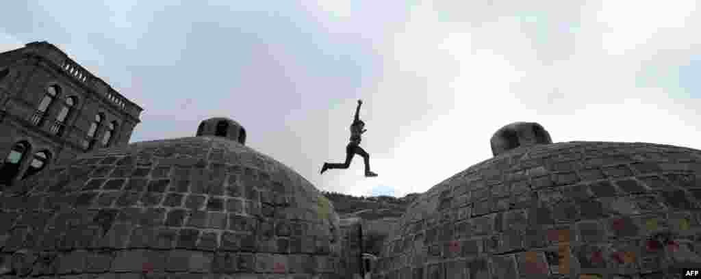 A Georgian boy jumps over the roofs of ancient sulfur bathhouses in Tbilisi on October 6.(AFP/Vano Shlamov)