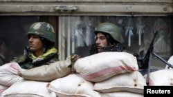 Syrian soldiers man a checkpoint in Homs on January 23.