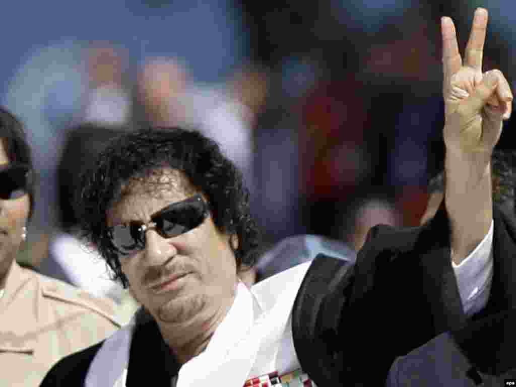 Qaddafi makes the victory sign as he arrives for a session at the G8 summit in L'Aquila, Italy, on July 10, 2009.