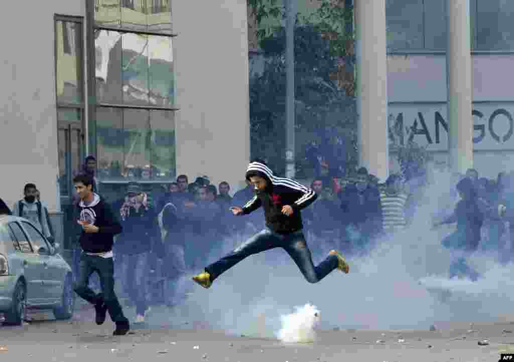 A Tunisian protester jumps amid smoke after police fired tear gas during a rally outside the Interior Ministry in Tunis to protest after opposition leader and outspoken government critic Chokri Belaid was shot dead. (AFP/Fethi Belaid)