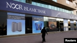 A woman walks past a branch of the Noor Islamic Bank in Dubai. Although there have long been many Islamic banks in the Middle East and Southeast Asia, they are now also spreading rapidly in the West. (file photo)