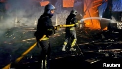 Firefighters work at a site of grain warehouses hit during a Russian drone strike in Uman in Ukraine's Cherkasy region on October 1.