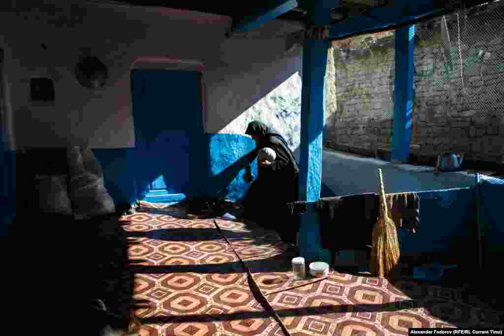 Musalmagomedova walks into her house. The deserted houses in the village deteriorate very quickly. Her&nbsp;home is at the end of&nbsp;a street piled with the debris of other houses.