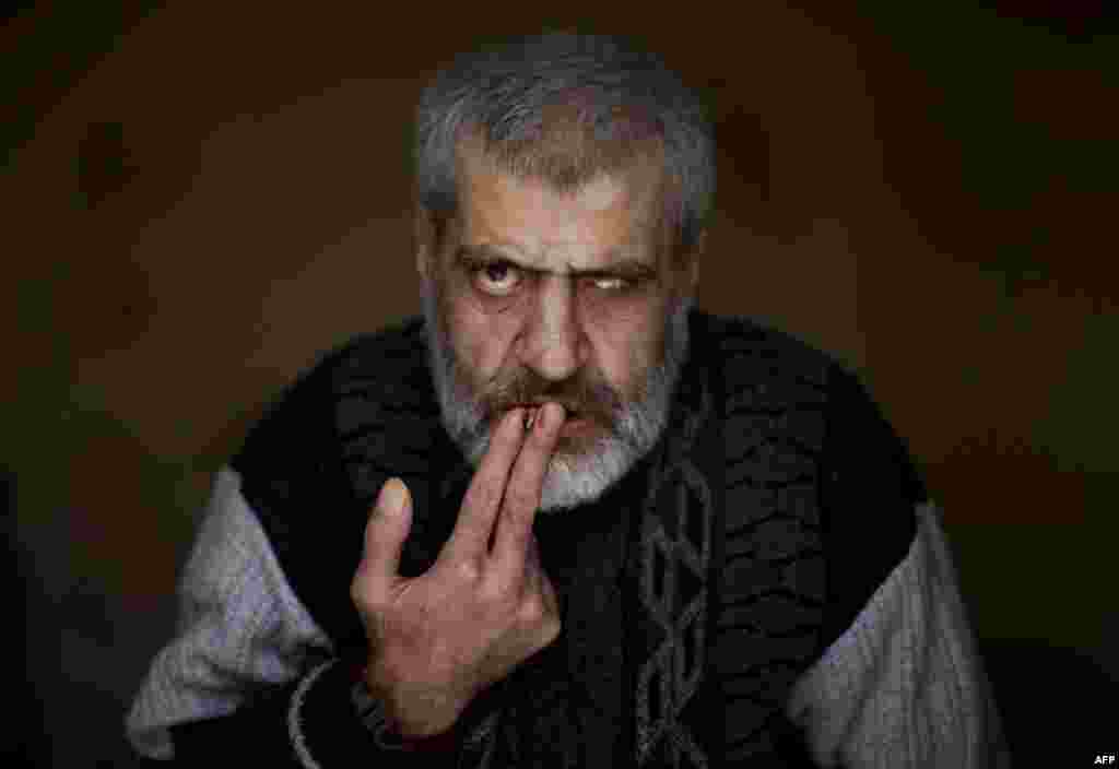 A Syrian patient smokes a cigarette at the Dar Al-Ajaza psychiatric hospital in the heart of the Old City of Aleppo. The psychiatric ward in Syria&#39;s war-ravaged second city, housing around 60 patients, has lacked the means to function properly since fighting broke out there in July. (AFP)