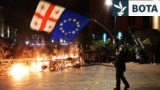 Një protestues valëvit flamurin e Gjeorgjisë dhe atë të BE-së gjatë protestave pas mbajtjes së zgjedhjeve lokale. Tbilisi, 4 tetor 2025. 