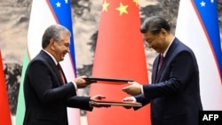 Uzbek President Shavkat Mirziyoyev (left) and Chinese President Xi Jinping attend a signing ceremony following talks in Beijing in January 2024 after agreeing to deepen their strategic partnership.