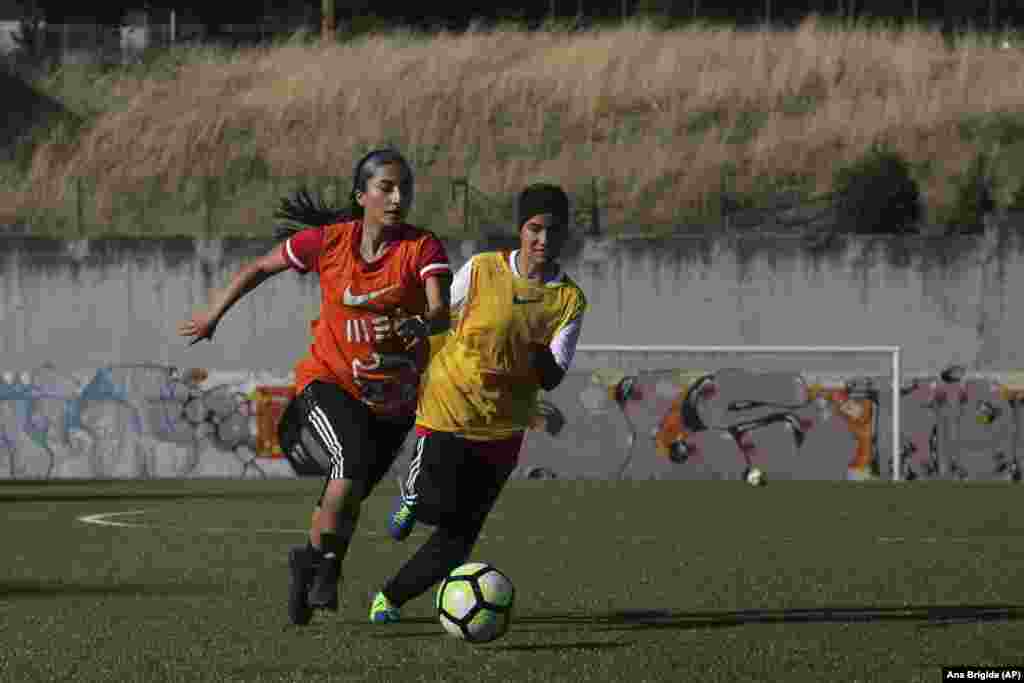 Captain Farkhunda Muhtaj (left) runs with the ball during a training session with her teammates at a soccer pitch in Odivelas on the outskirts of Lisbon on September 30.