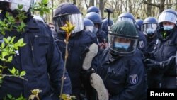 Pripadnici policije nose demonstranta tokom protesta protiv vladinih mjera za suzbijanje COVID-19, Berlin 21. aprila 2021. 