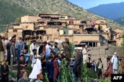 Afghans gather near damaged houses after earthquakes at Mazar Dara village in Nurgal district, Kunar Province, in eastern Afghanistan.