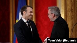 Emmanuel Macron francia elnök (b) üdvözli Luigi Ventura akkori pápai nunciust a párizsi Élysée-palotában 2018. január 4-én.