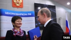 Russian Prime Minister Vladimir Putin (right) presents documentation for his candidacy in the 2012 presidential election, to a Central Electoral Commission official in Moscow on December 7.