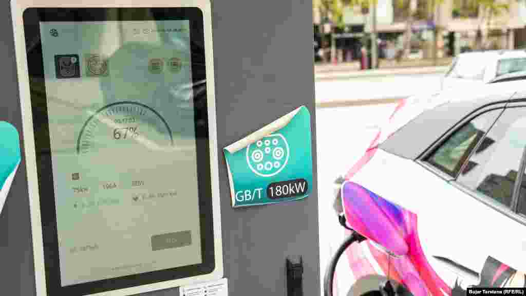 Një automjet elektrik, i një kompanie taksie, duke mbushur bateritë në një nga pikat në Prishtinë. Veturat elektrike konsumojnë mesatarisht 15 deri në 20 kWh për 100 kilometra. Kjo përkthehet në kosto dukshëm më të ulët: më pak se 1 euro për 100 kilometra nëse mbushja bëhet në shtëpi kur tarifat e energjisë janë më të ulëta apo 3-4 euro në pikat publike, sikurse kjo në foto. 