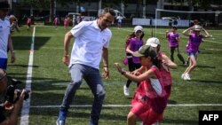 Former French football player Youri Djorkaeff plays with students of his childhood school on June 4, 2019 at the Charles de Rochefoucauld school in Lyon. (Photo by JEAN-PHILIPPE KSIAZEK / AFP)