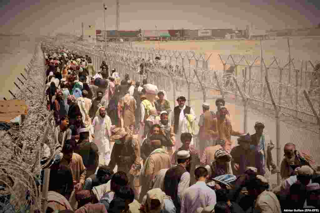 People stranded at the Pakistani-Afghan border wait to cross after it was reopened by Pakistani authorities at Chaman on August 13 after several days of closure due to disagreements with the Taliban in Afghanistan.