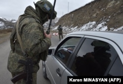 A Russian peacekeeper checks a vehicle at a checkpoint on a road outside Stepanakert on November 26, 2020.