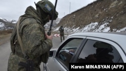 A Russian peacekeeper checks a vehicle on a road outside the town of Stepanakert on November 26, 2020, after six weeks of fighting between Armenia and Azerbaijan.