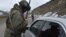 A Russian peacekeeper checks a vehicle on a road outside the town of Stepanakert on November 26, 2020, after six weeks of fighting between Armenia and Azerbaijan.