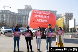 Activiștii de la Declic au protestat marți cu un ciolan gonflabil în fața Parlamentului, cerând întreruperea „ciolaniadei” interimatelor de la conducerile spitalelor, controlate astfel politic.