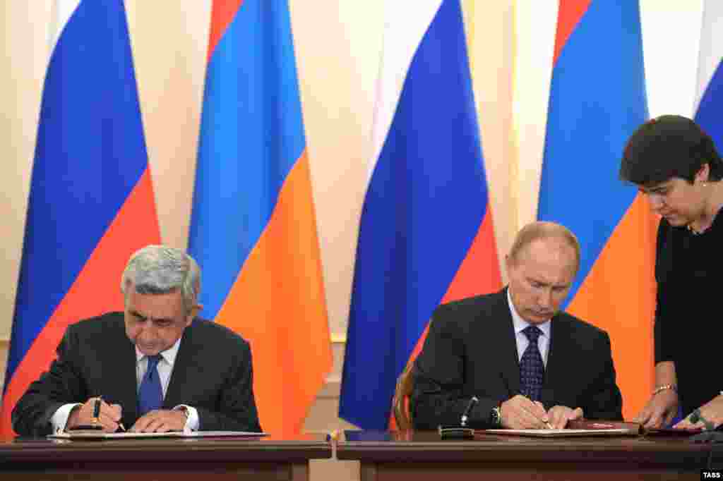 Președinții Armeniei, Serj Sarkisian, și Rusiei, Vladimir Putin, semnînd documentele comune, după întîlnirea de la reședința prezidențială de la Novo-Ogariovo