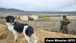 NAGORNO-KARABAKH -- A Russian peacekeeper patrols near a dog at a checkpoint outside Askeran, November 19, 2020