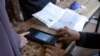 A woman's finger is scanned before casting her vote during parliamentary elections in Kandahar on October 27.