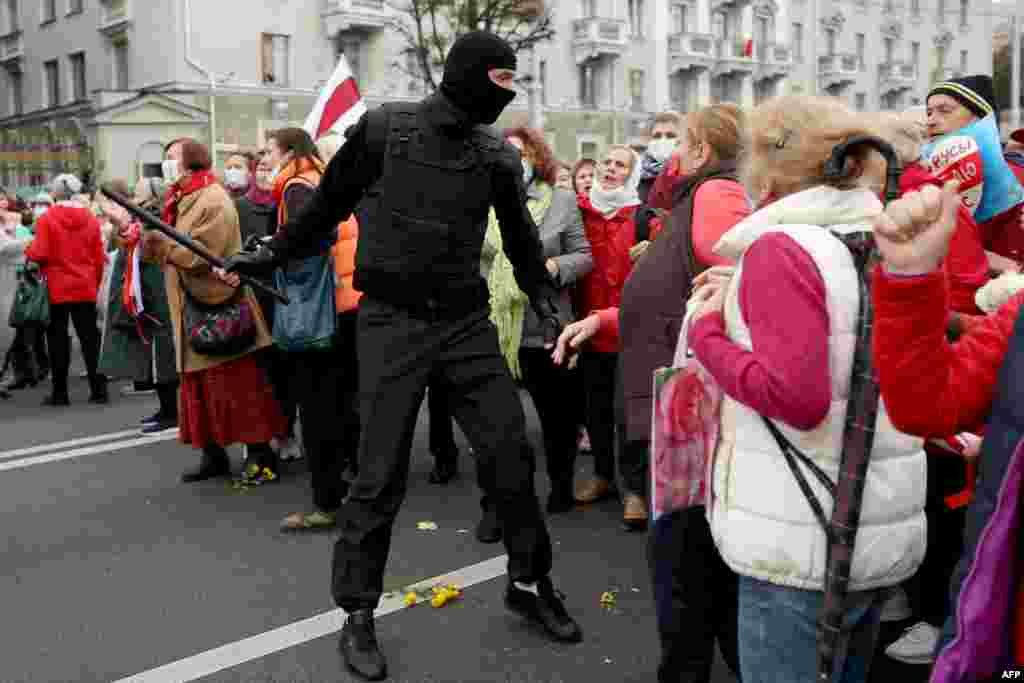 Pensionistët bjellorusë debatojnë me një zyrtar policor gjatë një tubimi në Minsk më 12, të organizuar kundër Aleksandar Lukashenkës. (AFP/Stringer)