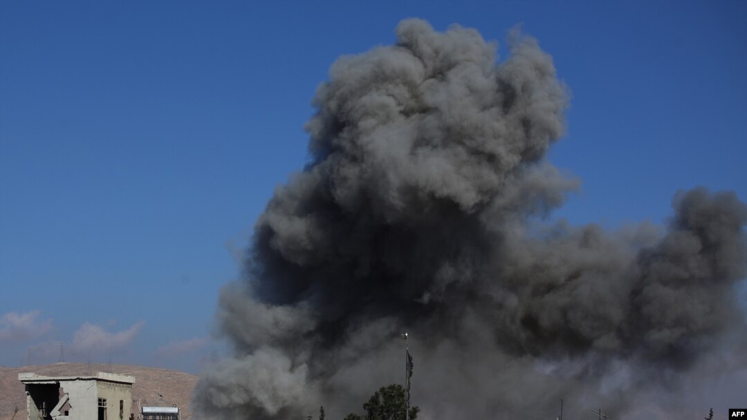 Дым над зданиями в городе Дума после авиаударов, нанесенных правительственными войсками, 23 декабря 2014 года 