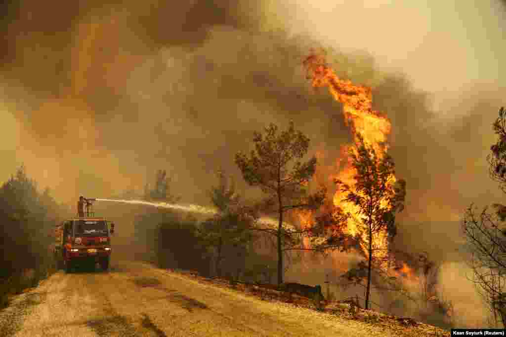 Пожарникар гасне шумски пожар во близина на градот Манавгат, источно од туристичкиот град Анталија, Турција, 30 јули 2021 година.
