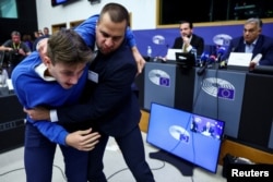 A security guard tackles a protester at Viktor Orban's Strasbourg news conference on October 8.