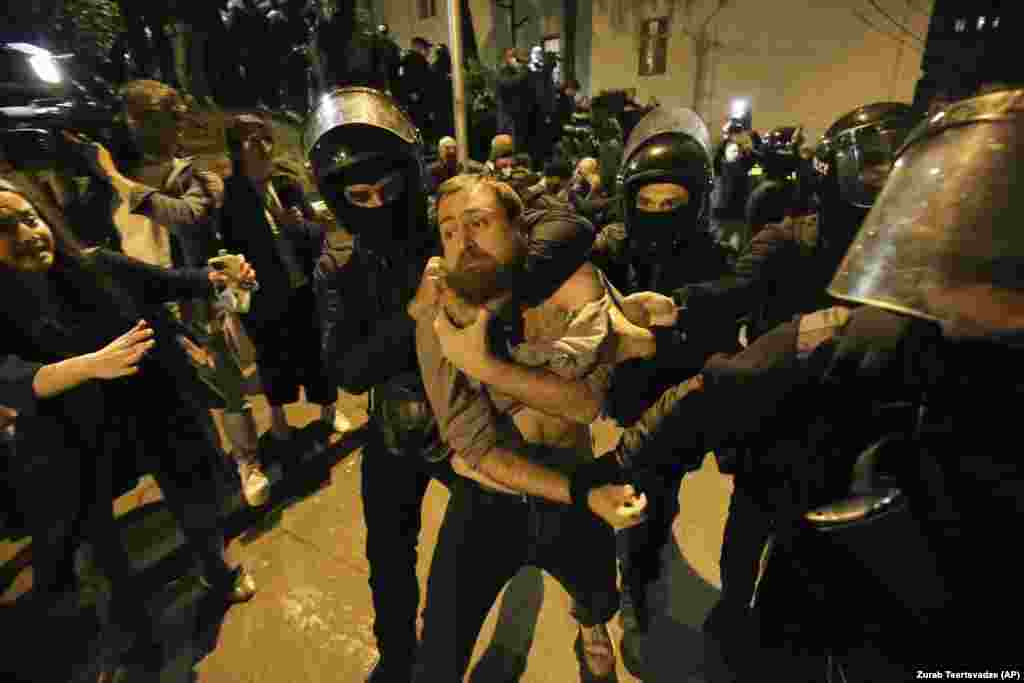 Police officers detain a protester during a demonstration outside the Georgian parliament building in Tbilisi against a controversial &quot;foreign agents&quot; bill on April 16.&nbsp;