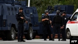 Kosovo's police officers stand guard at the entrance to the village of Banjska after one policeman was killed and another wounded in north Kosovo on September 24. 