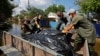 Комунальники і волонтери збирають тіла загиблих внаслідок потопу в окупованій Голій Пристані на Херсонщині, 16 червня 2023 року