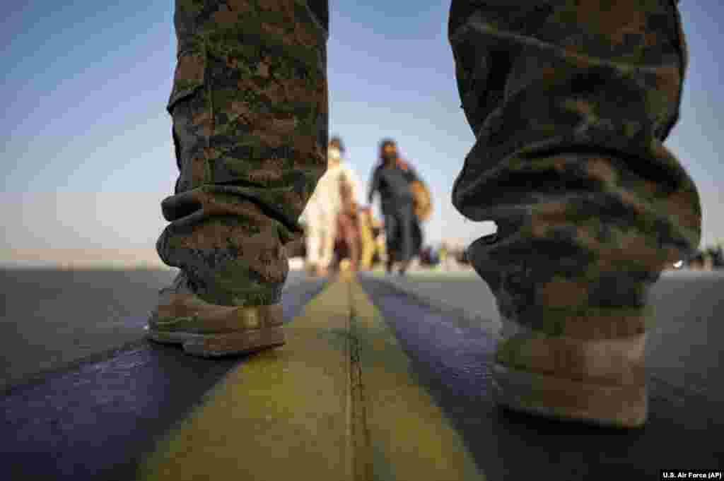 A U.S. Marine provides security for evacuees boarding a U.S.&nbsp; transport plane at Hamid Karzai International Airport in Kabul.&nbsp;