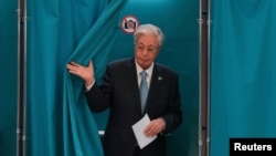 Kazakh President Qasym-Zhomart Toqaev emerges from a polling booth during Kazakhstan's parliamentary election on August 23.