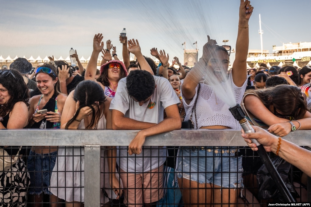 Një punonjës duke i flladitur pjesëmarrësit në festivalin e muzikës Les Deferlantes, në Le Barkares, Francë, më 29 qershor.