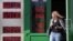RUSSIA -- A woman leaves exchange office with an electronic panel displaying currency exchange rates for U.S. dollar and euro against Russian ruble in Moscow, August 23, 2018