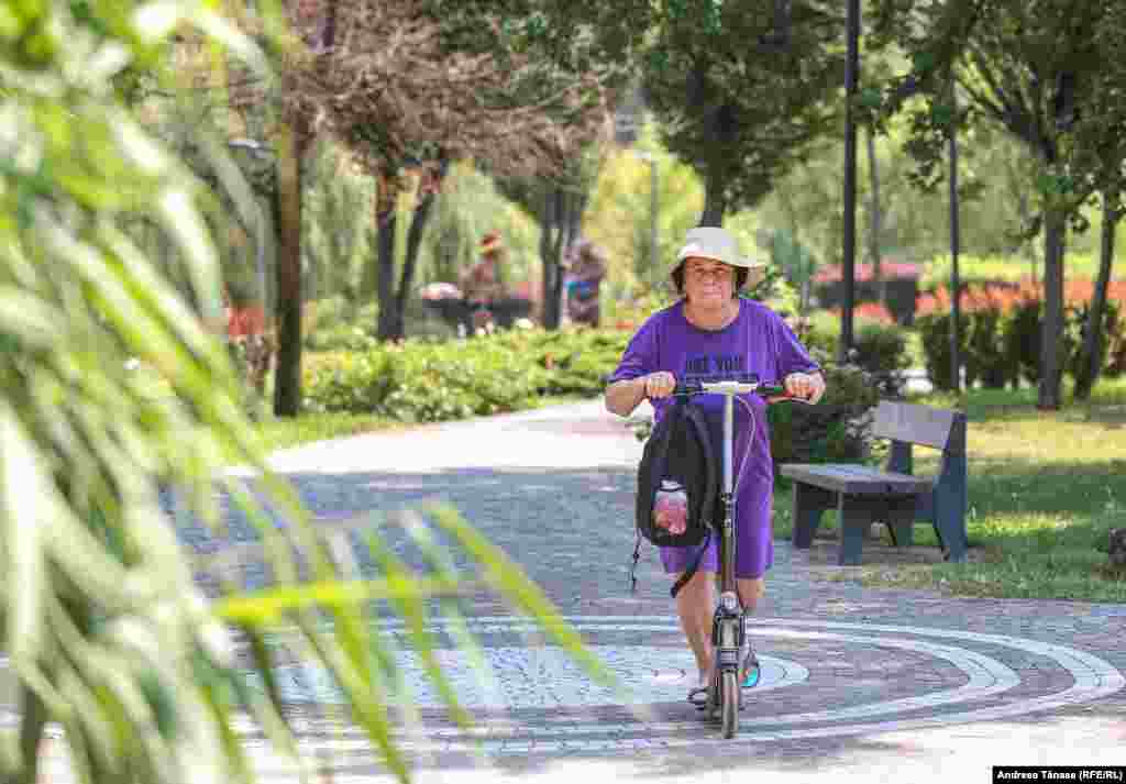 O femeie se plimbă pe tricicletă în Parcul Alexandru Ioan Cuza din București.&nbsp;