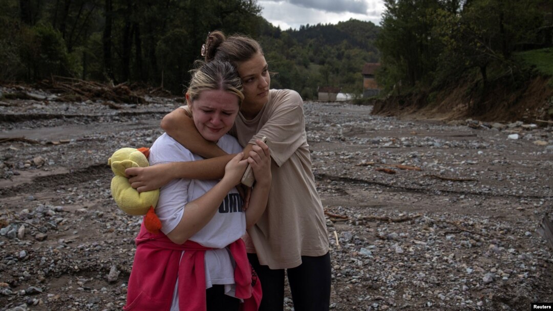 Two local woman react after floods and landslides hit the village of Trusina in Bosnia-Herzegovina. 