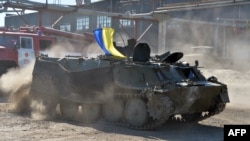 A serviceman of the volunteer Donbas Battalion practices driving an armored personnel carrier on July 28 captured from pro-Russian militants in the Ukrainian city of Lisichansk near Luhansk. 