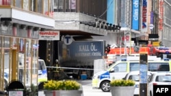 Emergency services work at the scene where the truck crashed into the Ahlens department store in central Stockholm.