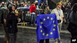 A demonstrator stands with a EU flag in front of police blocking an opposition protest against "the Russian law" near the parliament building in Tbilisi on May 1.