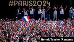 Луѓето се собираат во фан зоната на Олимпијадата во Париз за да ја гледаат церемонијата на затворање на игрите во Токио, пред Ајфеловата кула, во градините Трокадеро во Париз, Франција, 8 август 2021 година. 