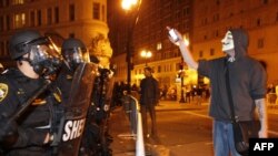 An "Occupy Oakland" protester who as part of the "Occupy Wall Street" movement stands in front of the police line as the police block streets in downtown Oakland on October 25.