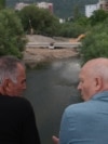Dy qytetarë duke shikuar ecurinë e punimeve në njërën nga urat e reja mbi Ibër.