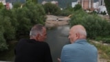 Dy qytetarë duke shikuar ecurinë e punimeve në njërën nga urat e reja mbi Ibër.