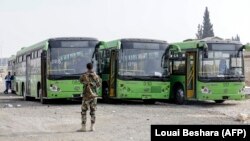 Автобуси чекають на жителів Східної Гути, які залишають регіон, біля пропускного пункту Вафідін, Сирія, 13 березня 2018 року