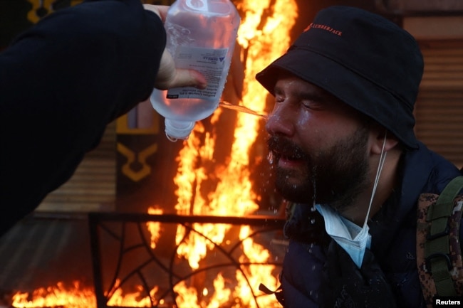 Një demonstrues duke u trajtuar pas prekjes nga gazi lotsjellës, më 13 tetor.